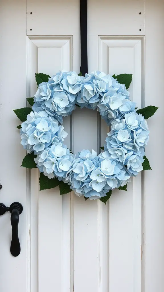 A classic hydrangea wreath with blue flowers and green leaves, hanging on a white door.