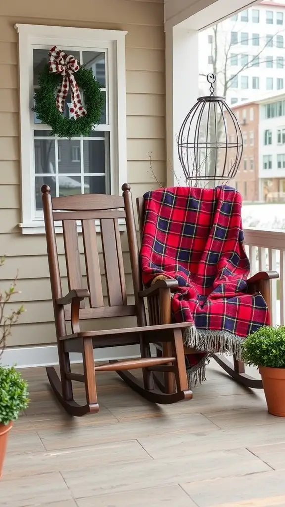 Cozy front porch featuring two rocking chairs, a plaid blanket, and a festive wreath.