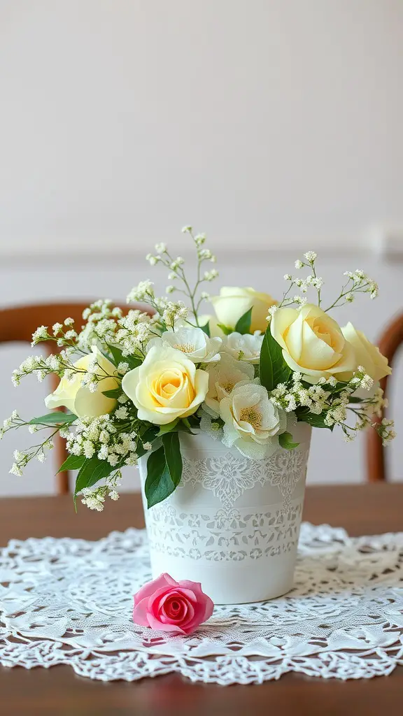 A floral arrangement with yellow roses in a lace-patterned white pot, with a pink rose on a lace doily.