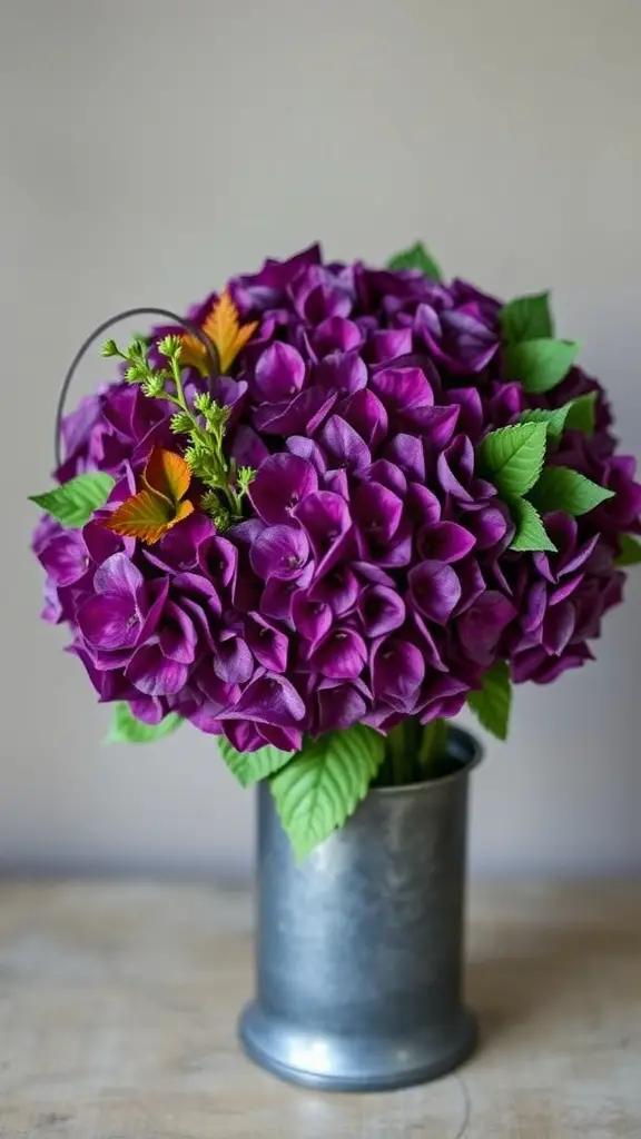 Rich purple hydrangea centerpiece with seasonal greens in a metallic vase.