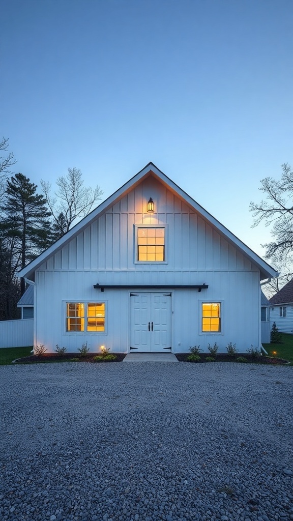 35+ Unique Pole Barn House Plans You'll Love 14 A white pole barn house with large windows and a welcoming entrance, surrounded by a gravel driveway.