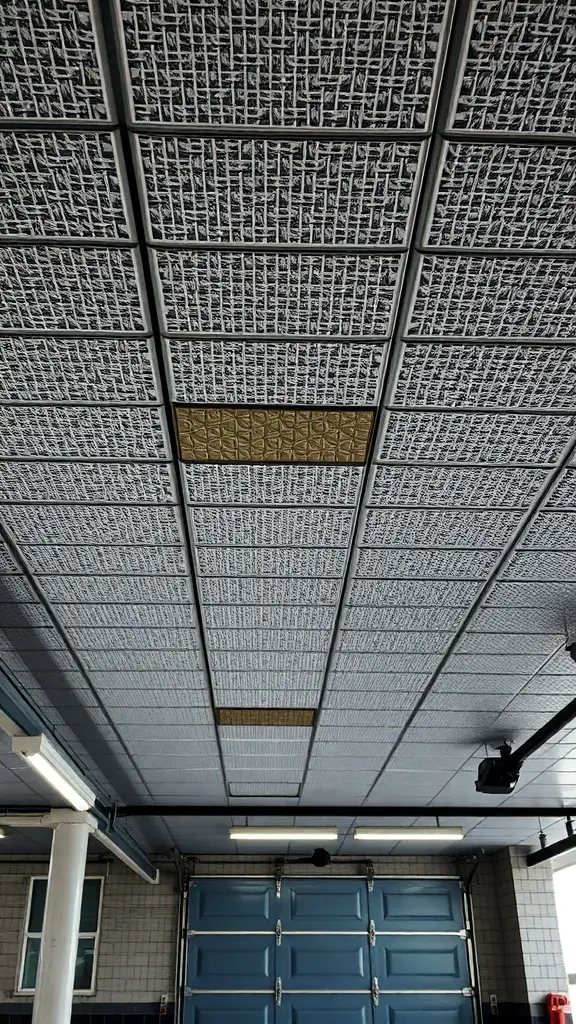 Textured ceiling tiles in a garage with a mix of patterns and colors.