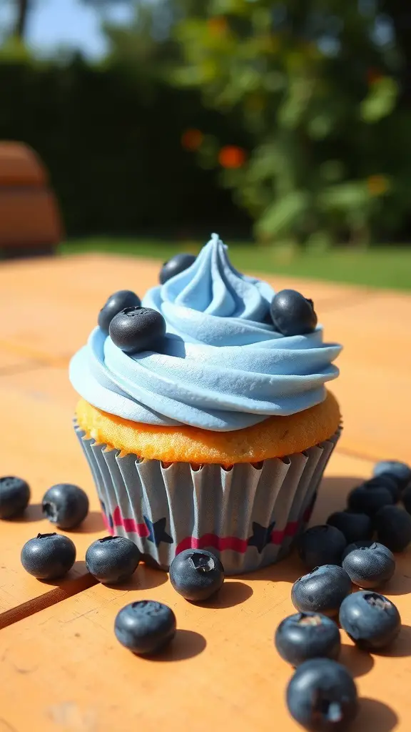 A cupcake with blue frosting and blueberries on top, placed on a wooden table.