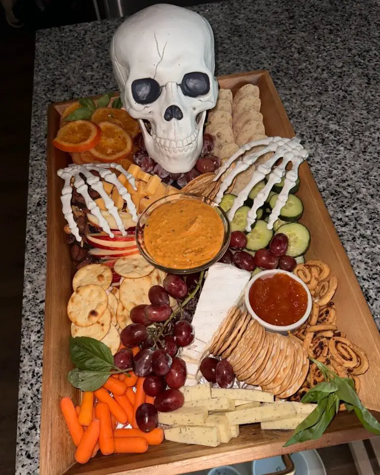 39 Spooky Charcuterie Board Ideas For Your Next Halloween Party 2 Skeleton hand Halloween charcuterie board with a skull, cheese, crackers, fruit, vegetables, and dips