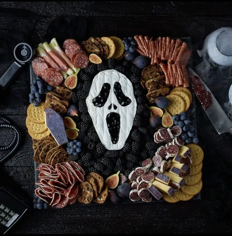 39 Spooky Charcuterie Board Ideas For Your Next Halloween Party 5 Ghost face Halloween charcuterie board with brie, crackers, cured meats, berries, grapes, and figs