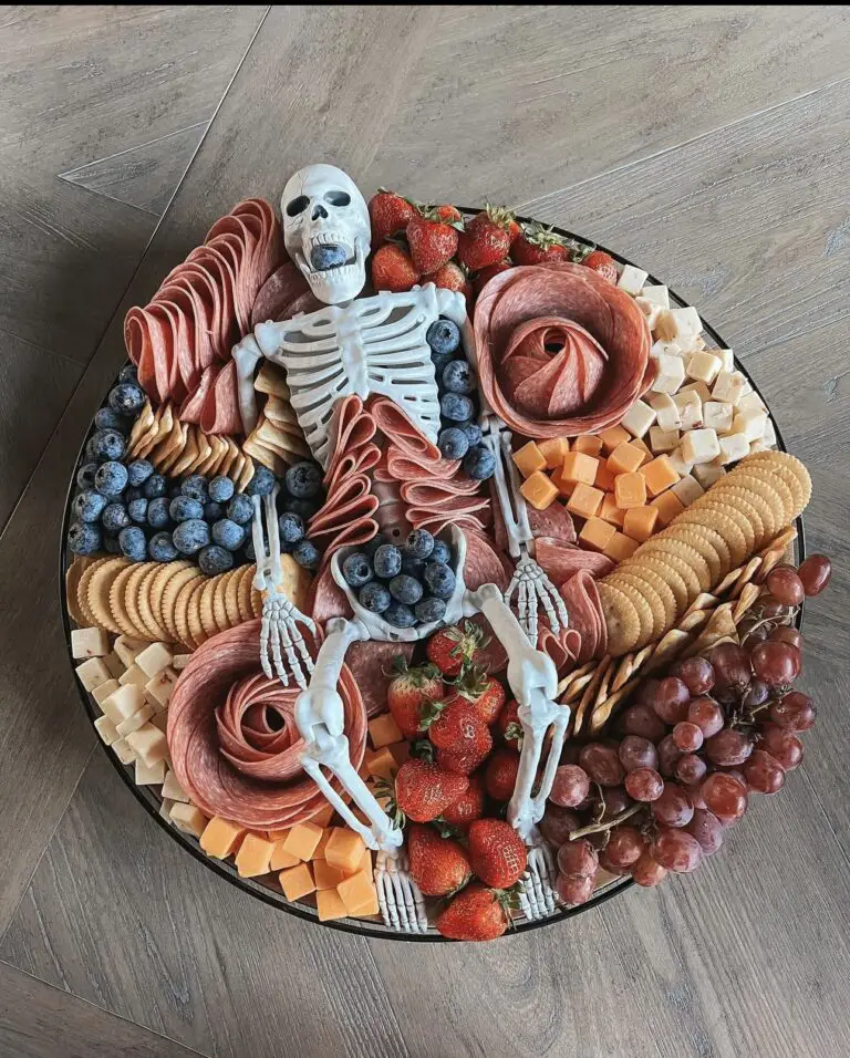 39 Spooky Charcuterie Board Ideas For Your Next Halloween Party 6 Skeleton platter charcuterie board with salami, cheese, crackers, strawberries, blueberries, and grapes