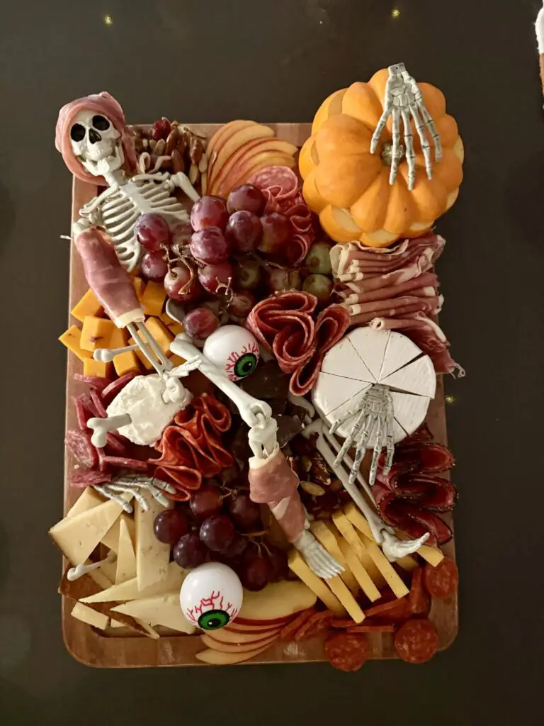 39 Spooky Charcuterie Board Ideas For Your Next Halloween Party 8 Skeleton and pumpkin Halloween charcuterie board with cheese, cured meats, grapes, apples, and candy eyeballs