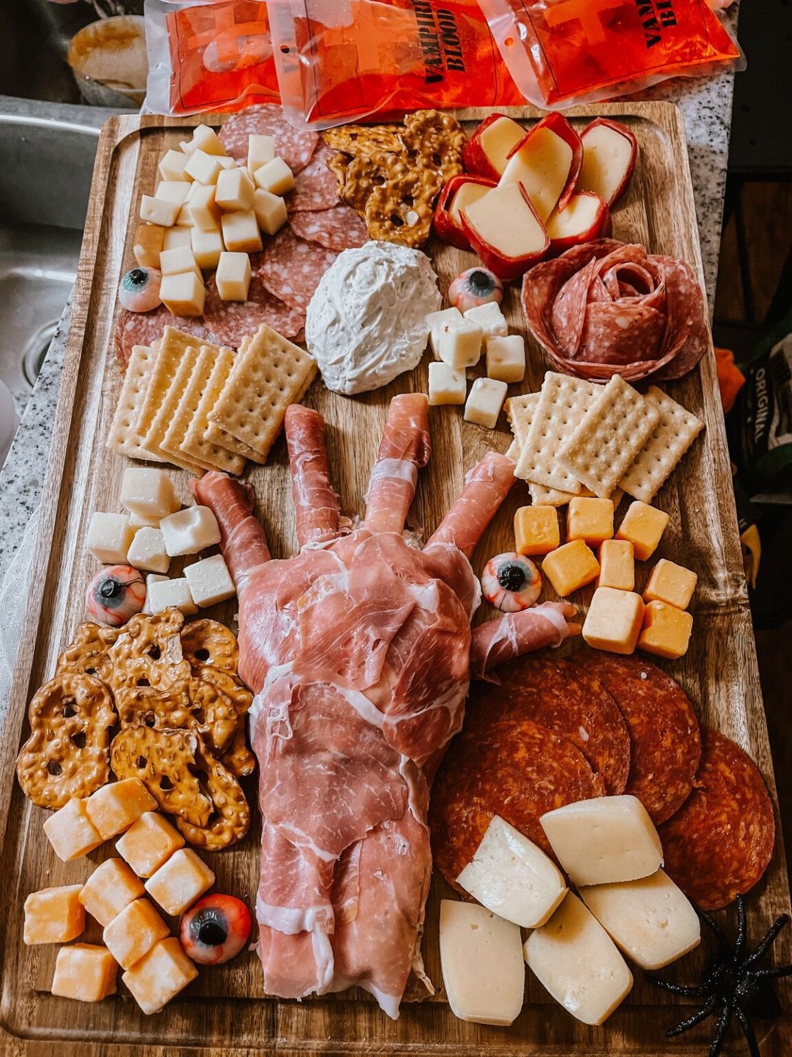 39 Spooky Charcuterie Board Ideas For Your Next Halloween Party 9 Prosciutto monster hand charcuterie board with crackers, cheeses, pepperoni, salami, and pretzels