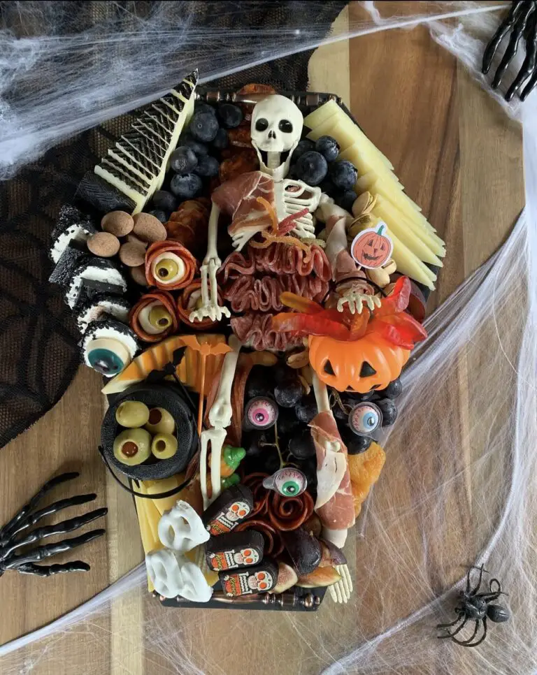 39 Spooky Charcuterie Board Ideas For Your Next Halloween Party 14 Skeleton coffin charcuterie board with meats, cheeses, grapes, olives, crackers, candy, and spooky decorations