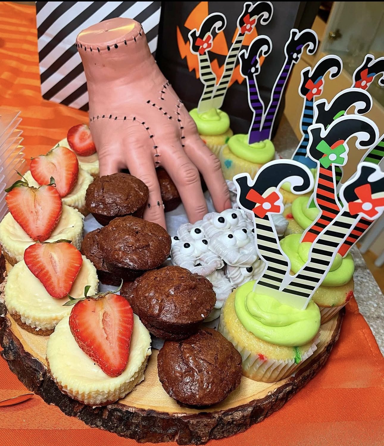 41 Spooky Dessert Board Ideas for Halloween Parties 3 Halloween dessert board with cheesecakes, muffins, cupcakes, and spooky decorations