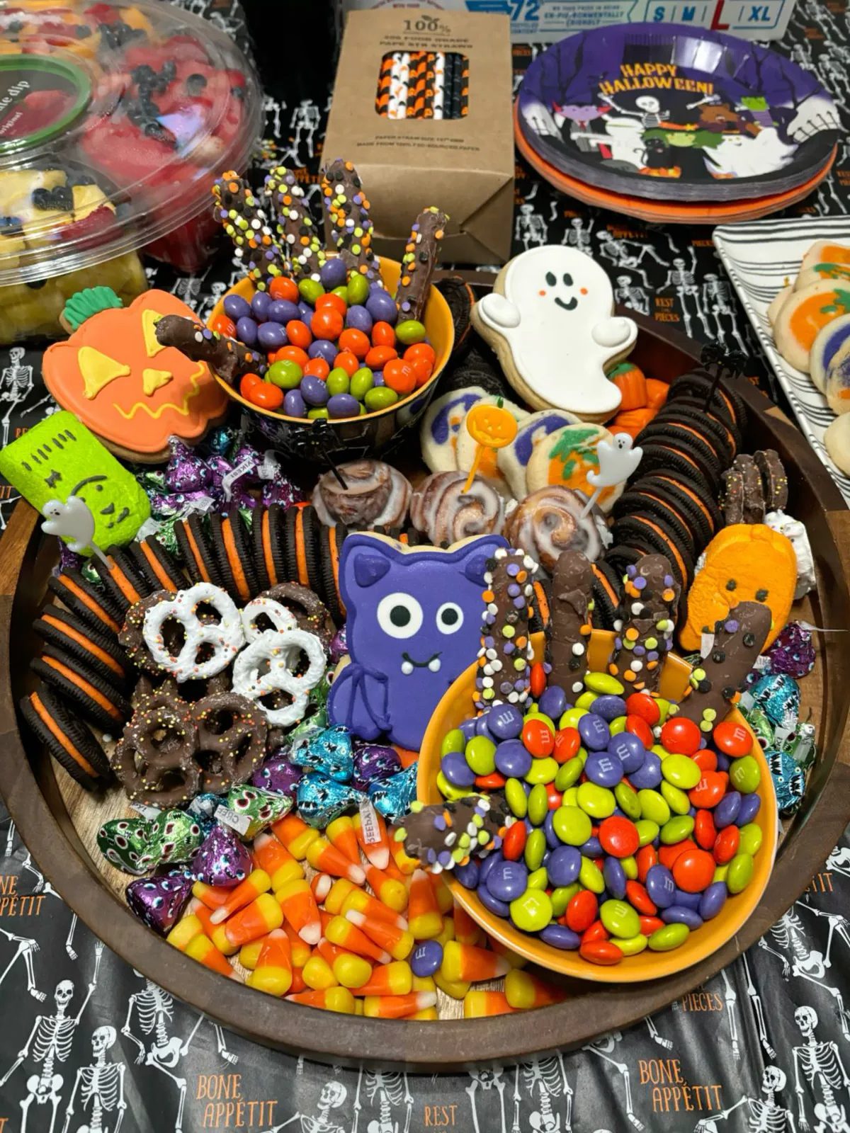 41 Spooky Dessert Board Ideas for Halloween Parties 7 Colorful Halloween dessert board with decorated cookies, candy, pretzels, and chocolates