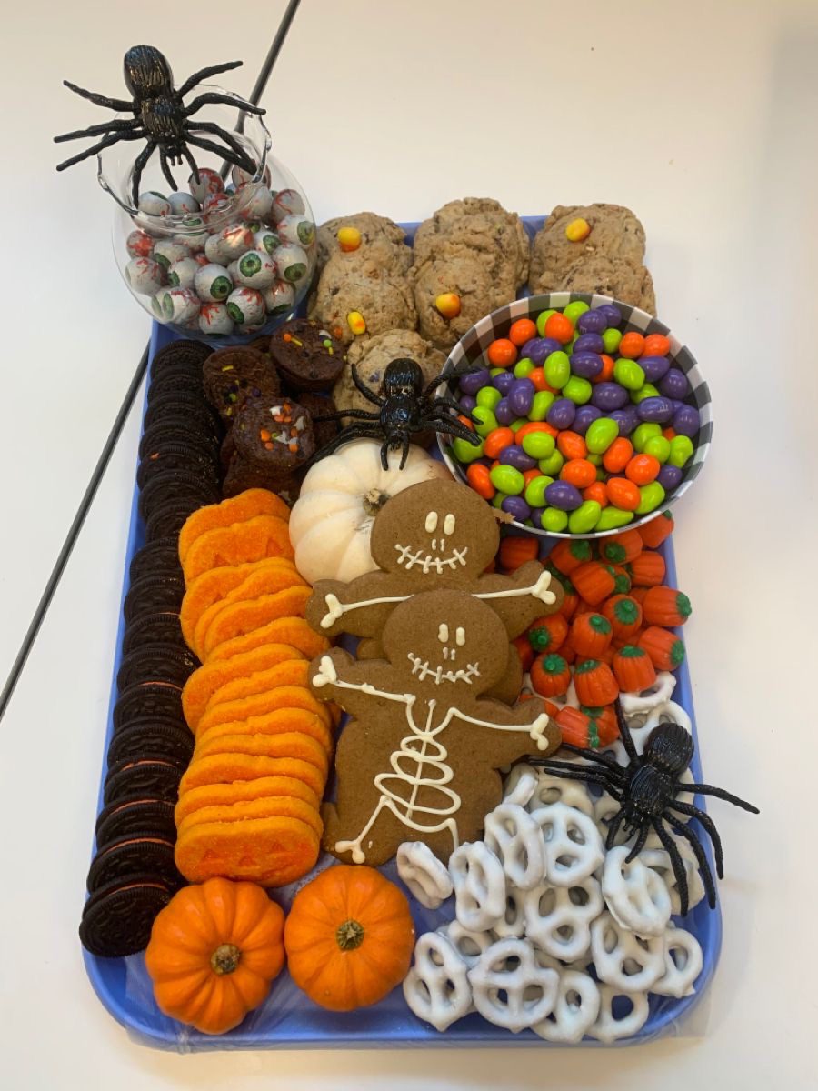41 Spooky Dessert Board Ideas for Halloween Parties 14 Halloween cookie board with gingerbread skeletons, sandwich cookies, pretzels, candies, and pumpkins