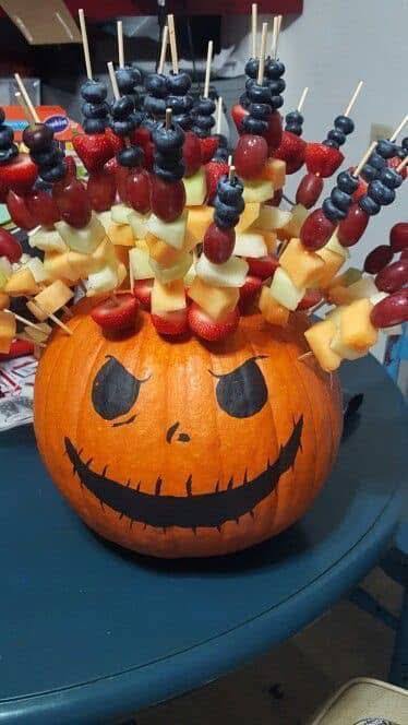 27 Halloween Treats for Kids and Adults That Everyone Will Love 7 Fruit skewers arranged inside a carved Halloween pumpkin