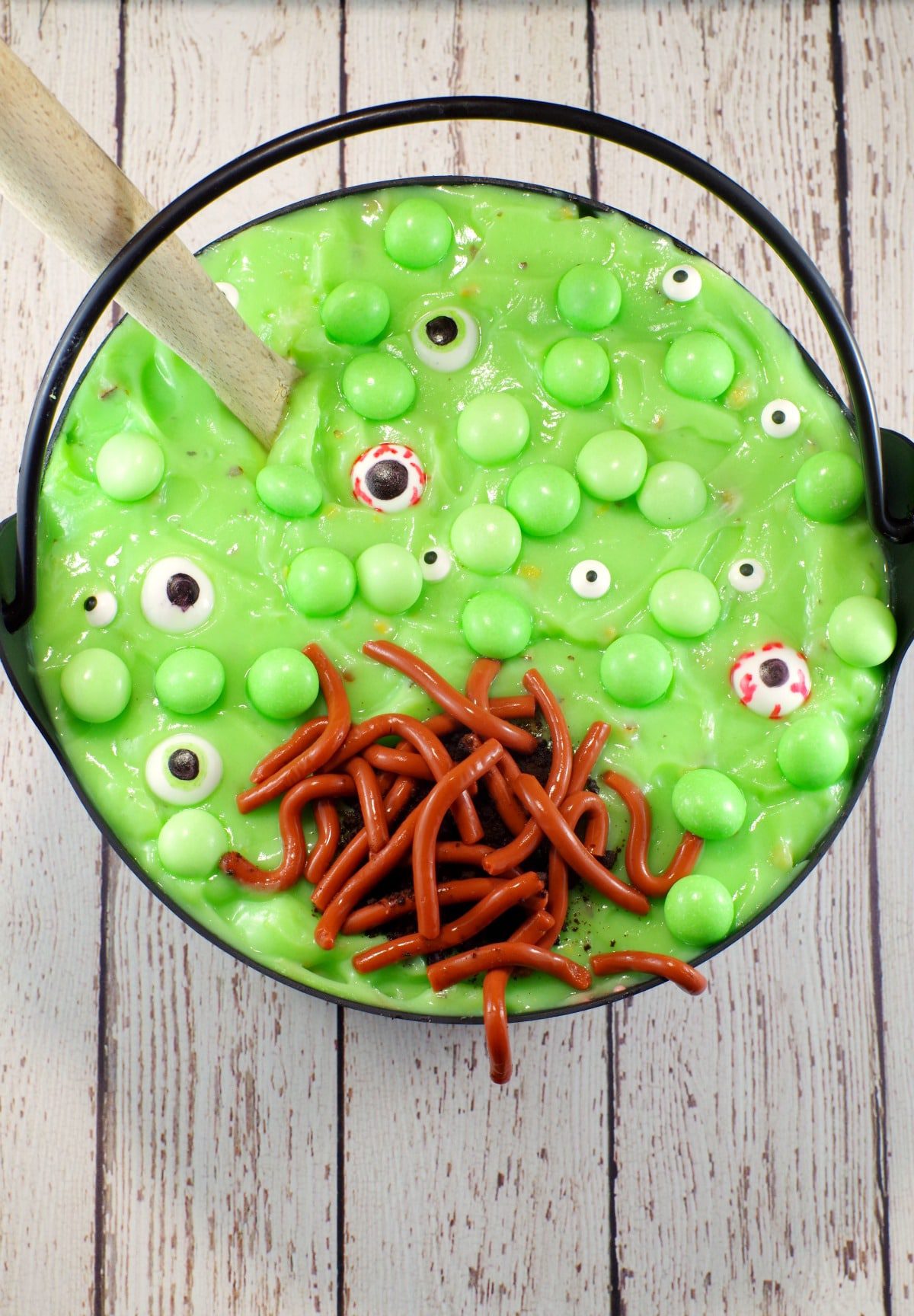 27 Halloween Treats for Kids and Adults That Everyone Will Love 12 Green witch cauldron dessert dip with candy eyes and gummy worms