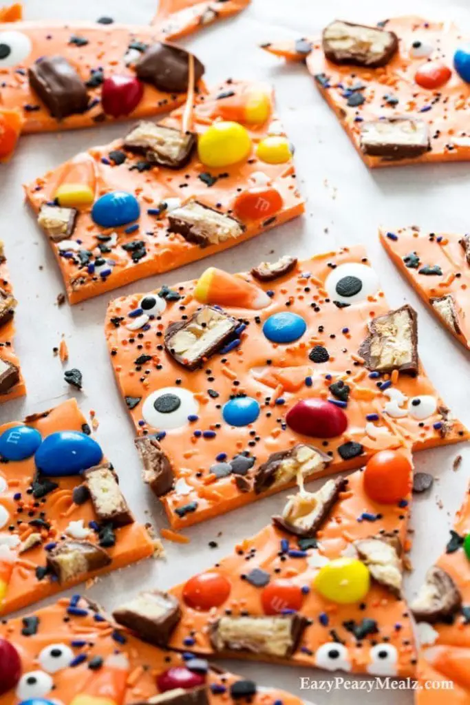 27 Halloween Treats for Kids and Adults That Everyone Will Love 23 Orange Halloween candy bark with candy corn and chocolate pieces