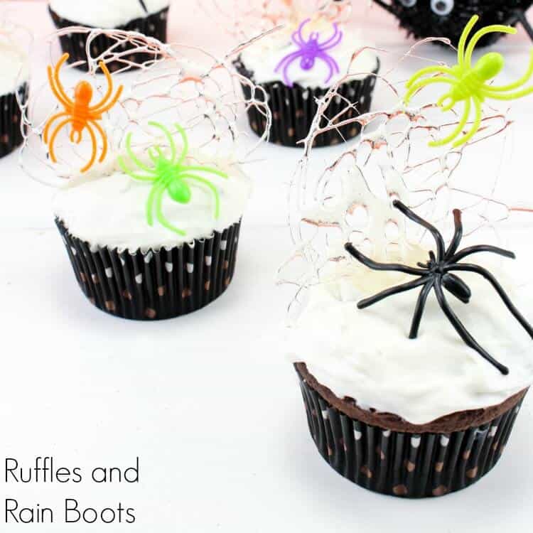 27 Halloween Treats for Kids and Adults That Everyone Will Love 25 Halloween cupcakes topped with white spider webs and colorful spiders