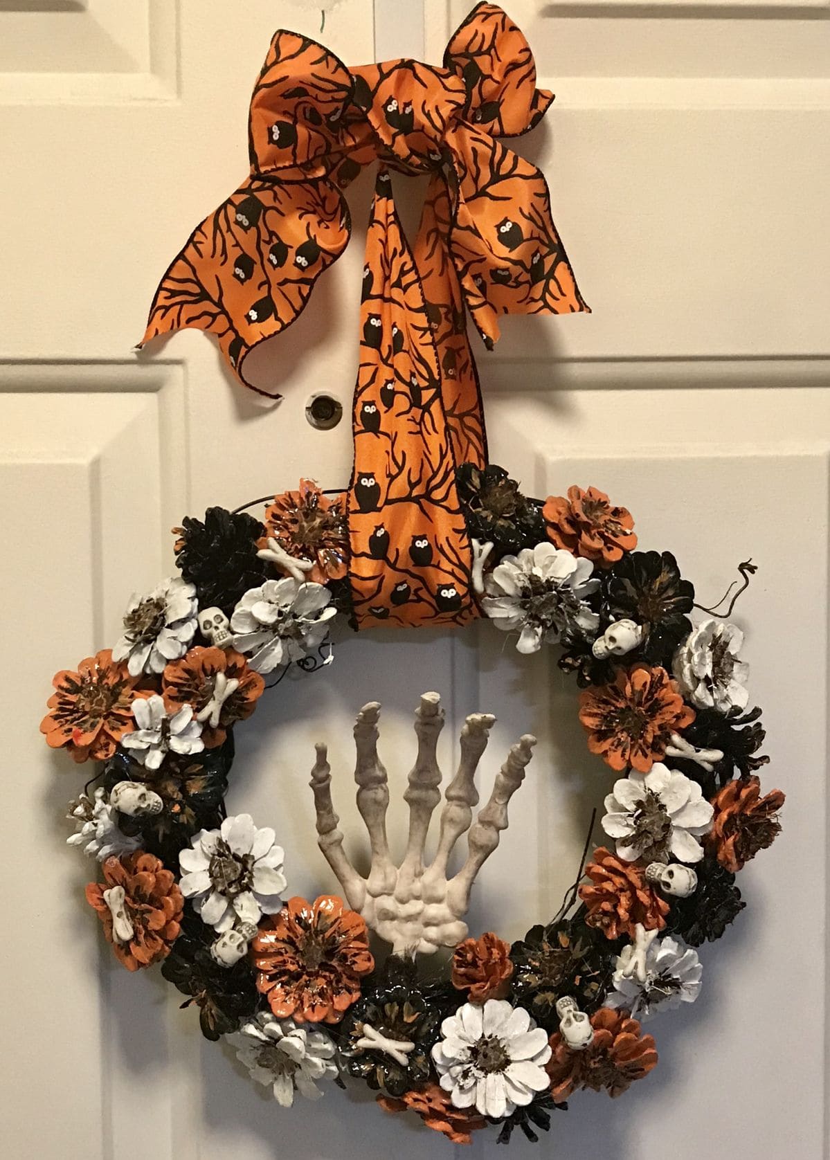 27 Halloween Wreath Ideas to Give Your Front Door a Spooky Touch 5 Pinecone Skeleton Hand Wreath