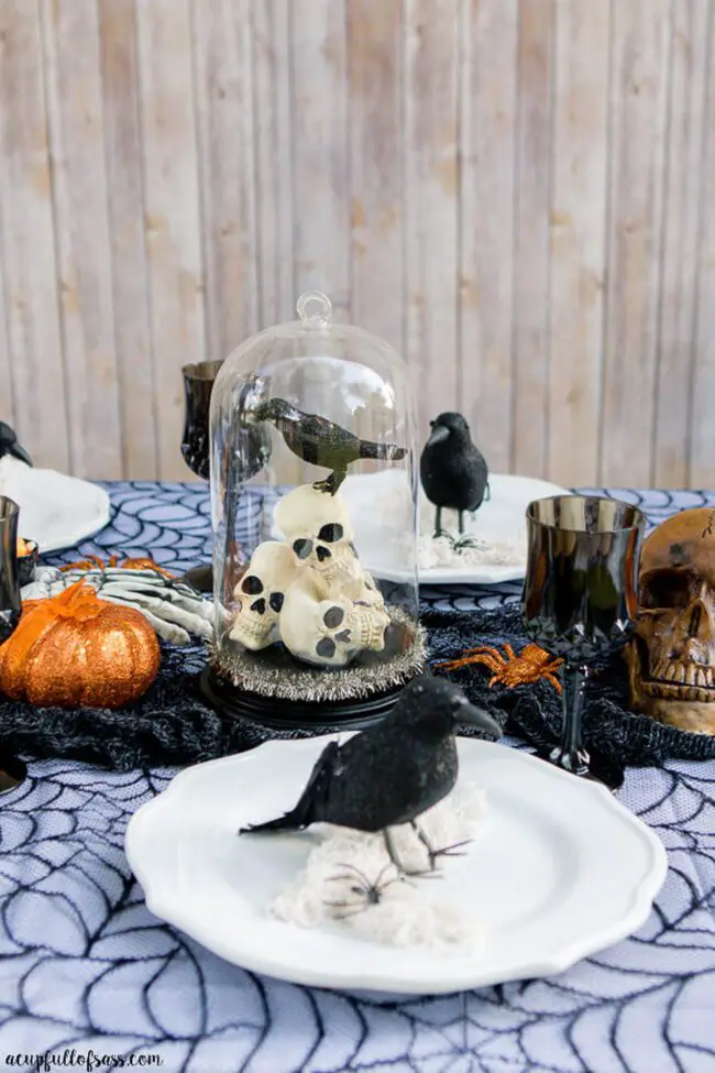 31 Indoor Halloween Decorations Ideas to Make Your Home Spooktacular 15 Crow and Skull Glass Cloche Centerpiece