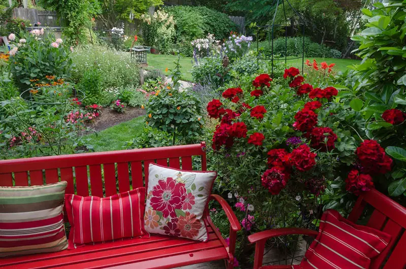 Vibrant Red Seating Nook Surrounded by Flowers