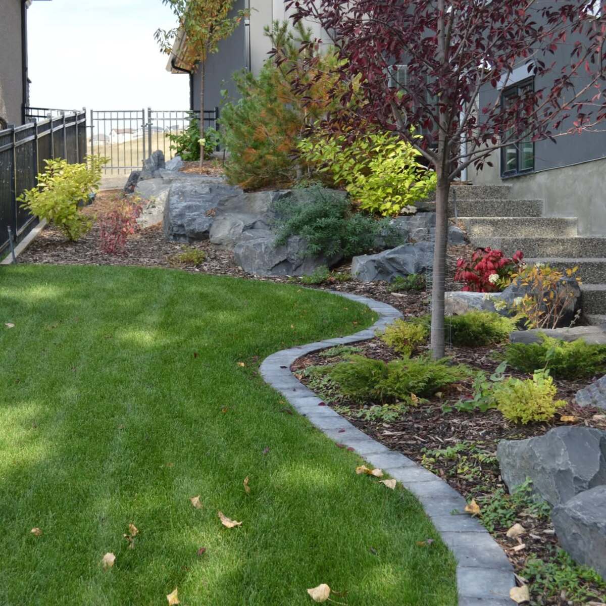 29 Brick Landscaping Ideas to Give Your Yard Timeless Charm 21 S Shaped Stone Border with Rock Outcroppings