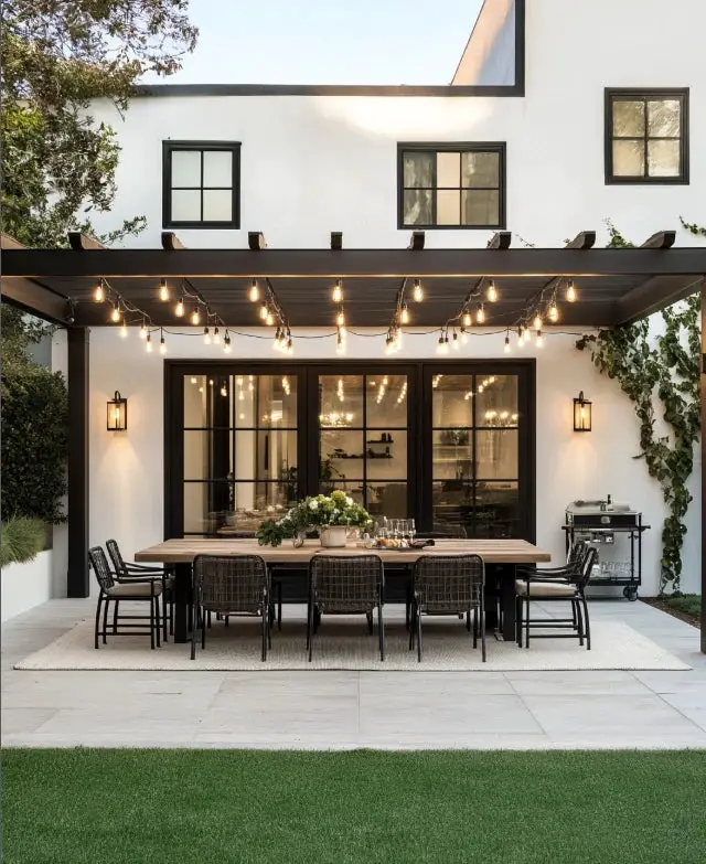 31+ Outdoor String Lighting Ideas for a Cozy and Beautiful Backyard 11 Dark wooden pergola with warm globe string lights above dining furniture