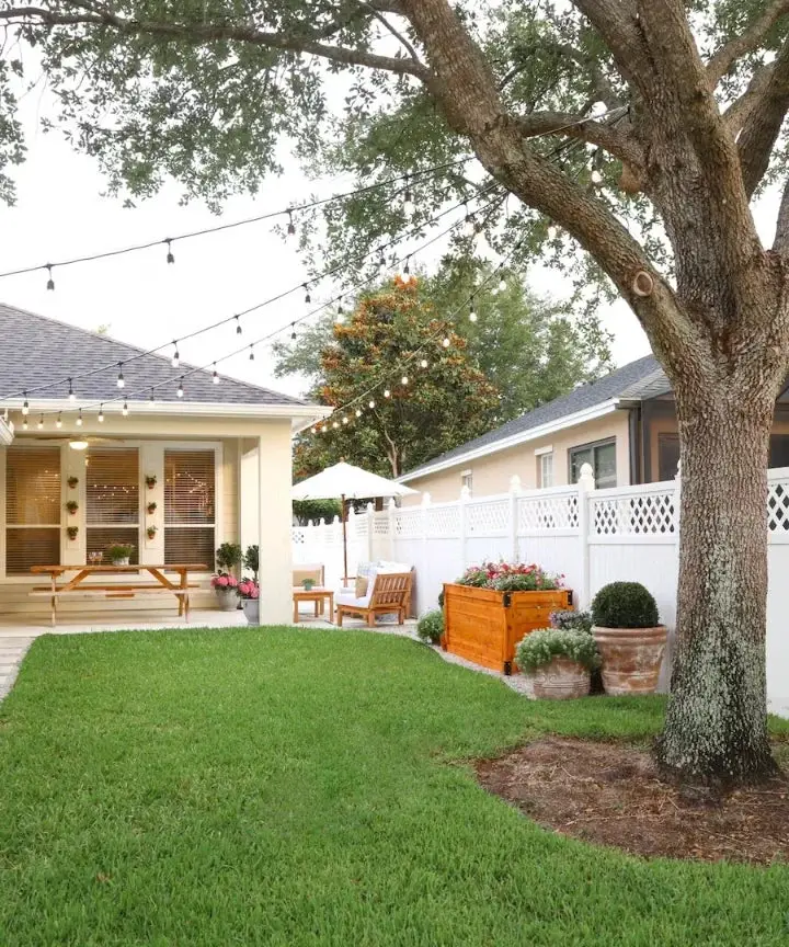 31+ Outdoor String Lighting Ideas for a Cozy and Beautiful Backyard 14 Outdoor string light canopy stretching from a backyard tree to a house